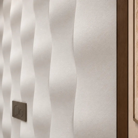 Vue rapprochée des panneaux muraux 3D en plâtre Drop montrant leur texture mate et leur relief courbé à côté d’une bordure en bois foncé