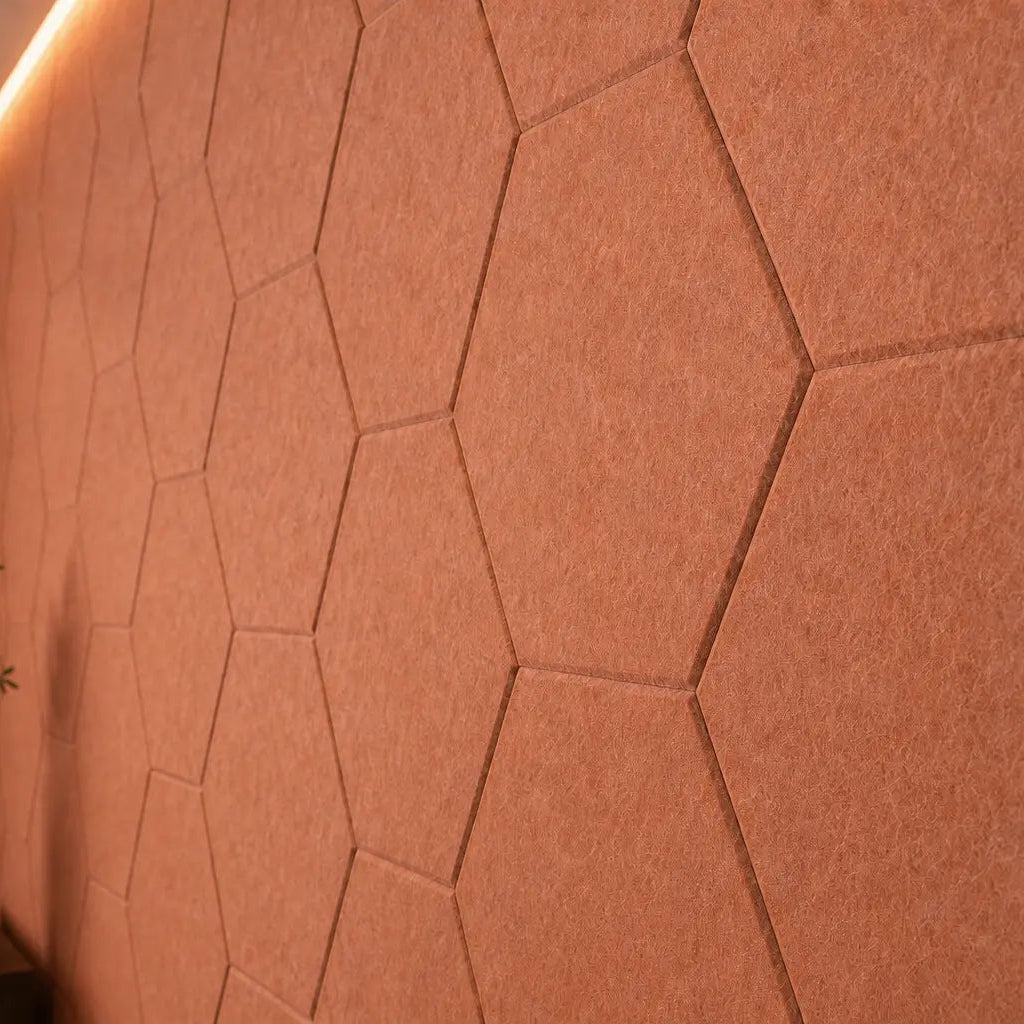 Orange HEXA 3D felt PET wall panels in an elegant dining room with a dark wooden table, upholstered chairs and pendant lighting close up view