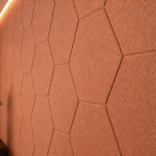Orange HEXA 3D felt PET wall panels in an elegant dining room with a dark wooden table, upholstered chairs and pendant lighting close up view