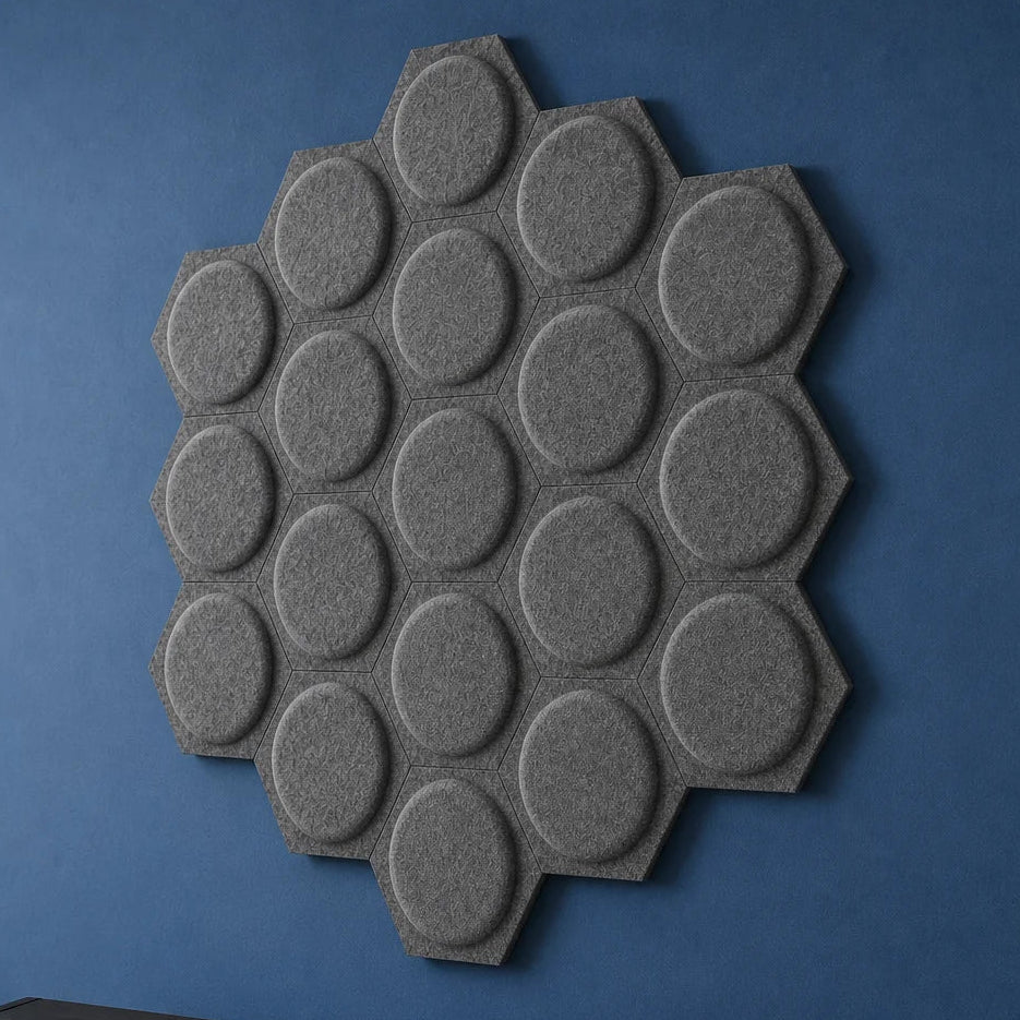Close-up of grey hexagonal felt acoustic panels with raised circular centres mounted on a blue wall