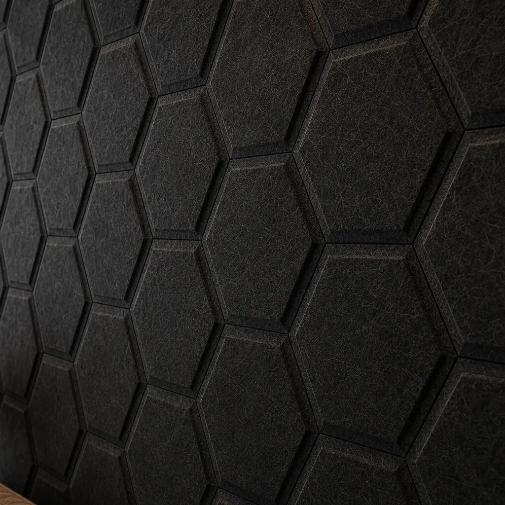 Close-up of black HEXA BOLD 3D acoustic felt wall panels, highlighting their hexagonal relief, precise joints and detailed fibrous texture