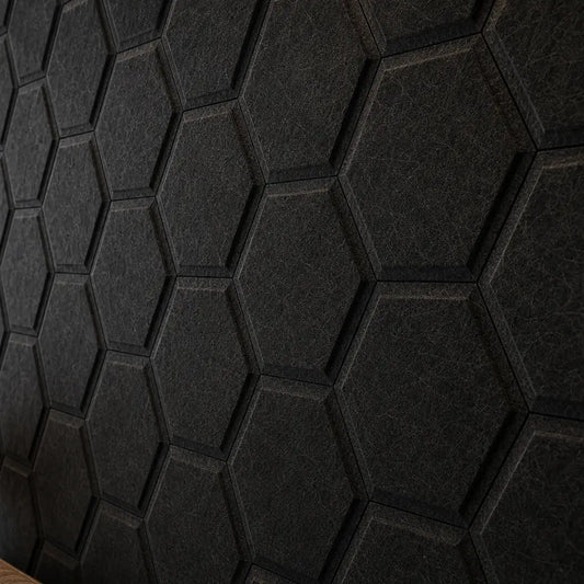 Close-up of black HEXA BOLD 3D acoustic felt wall panels, highlighting their hexagonal relief, precise joints and detailed fibrous texture