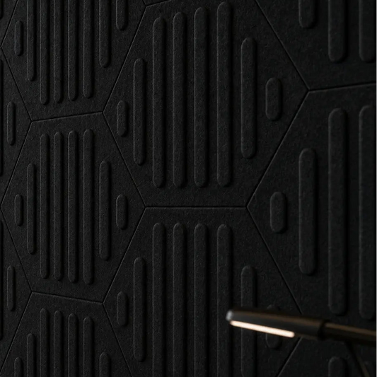Close-up of black HEXA RIFT 3D felt wall panels showing the geometric layout, raised relief and fibrous texture