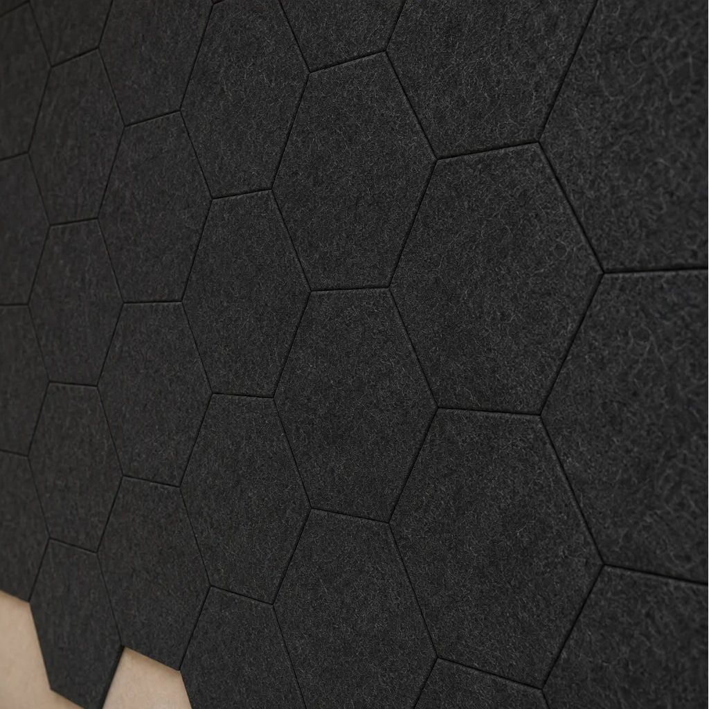 Close-up of flat black hexagonal felt acoustic panels showing their honeycomb layout and textured surface