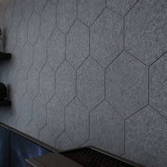 Close-up of grey flat hexagonal felt panels showing precise joints and a dense fibrous texture