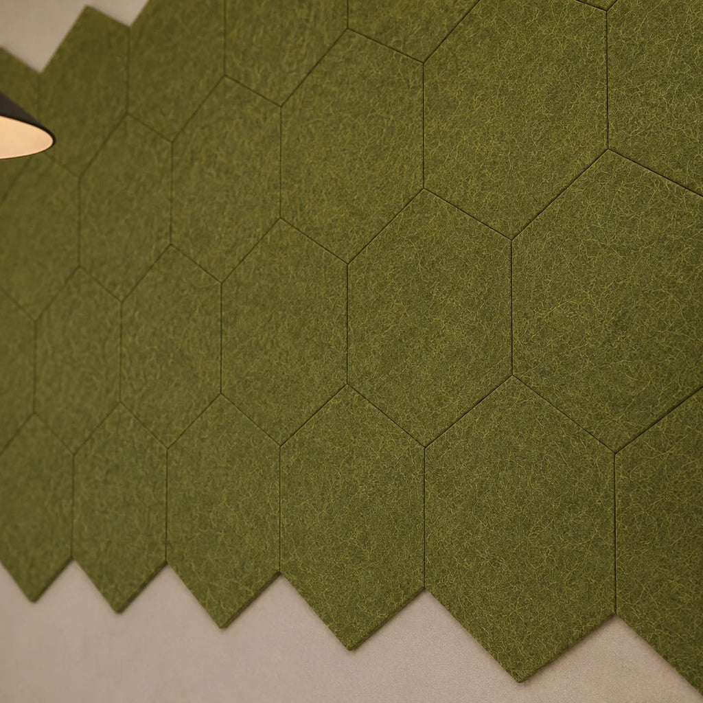 Close-up of olive hexagonal acoustic panels showing their flat profile, precise joints and fibrous felt texture