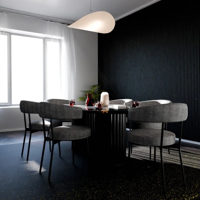 Contemporary dining room with grey upholstered chairs, a black table and a feature wall covered with black vertical fluted panels.