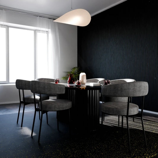 Contemporary dining room with grey upholstered chairs, a black table and a feature wall covered with black vertical fluted panels.