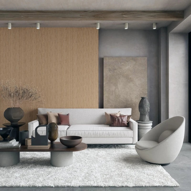 Contemporary living room with a white sofa, sculptural armchair and a natural oak wave-panel feature wall contrasting with grey concrete surfaces