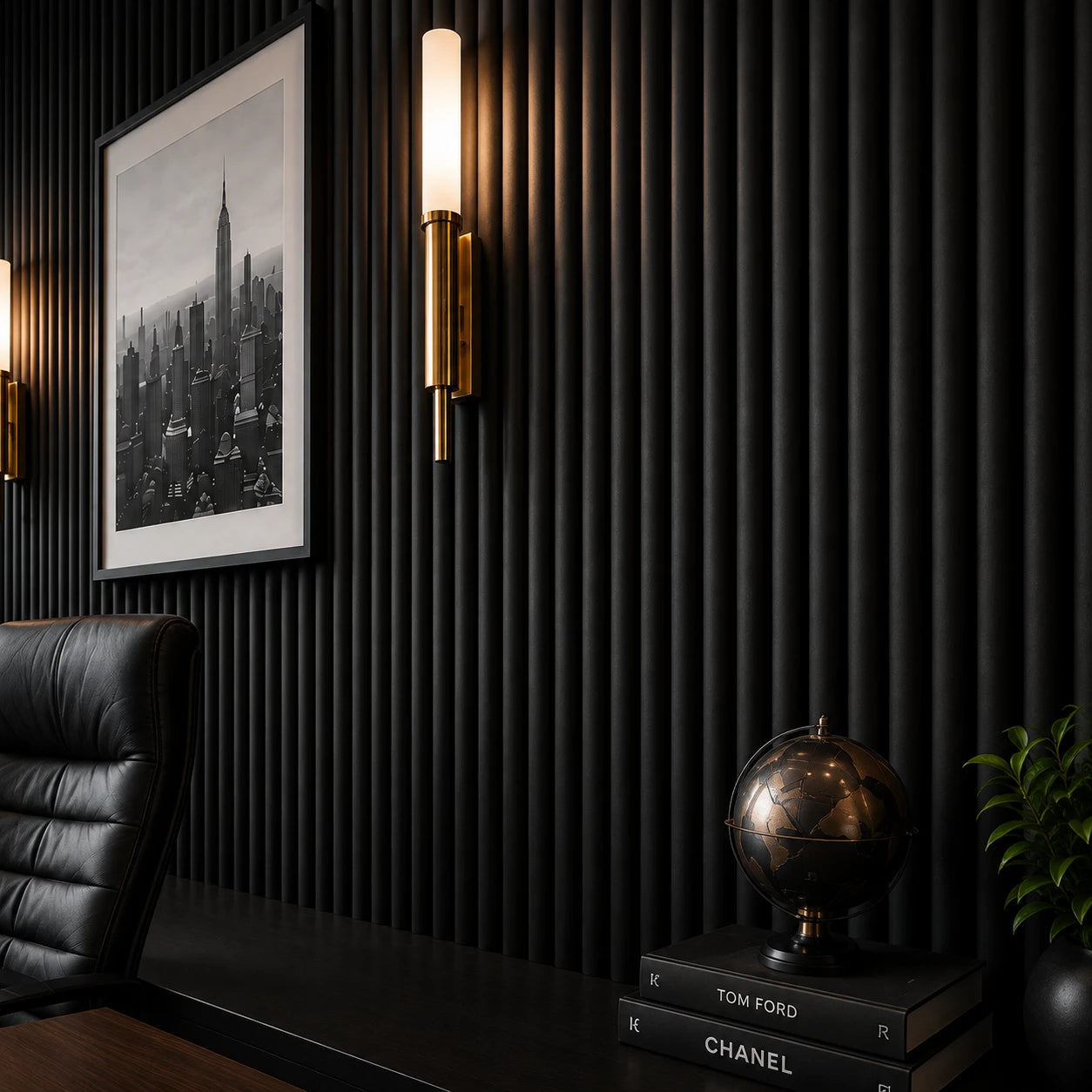Close-up of matte black fluted wall panels with rounded raised profiles, complemented by a brass wall light, framed black-and-white city artwork, a decorative globe, books, and a green plant