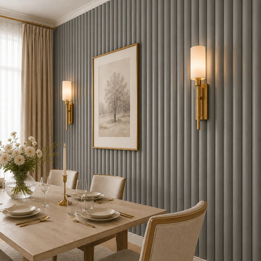 Close-up angled view of grey convex fluted wall panels in a refined dining room, featuring brass wall sconces, framed tree artwork, neutral curtains, and part of a fully set dining table