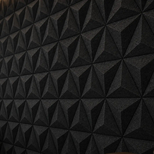 Close-up of black PYRAMID 3D acoustic felt wall panels, showing the geometric pattern, subtle relief and textured PET felt surface