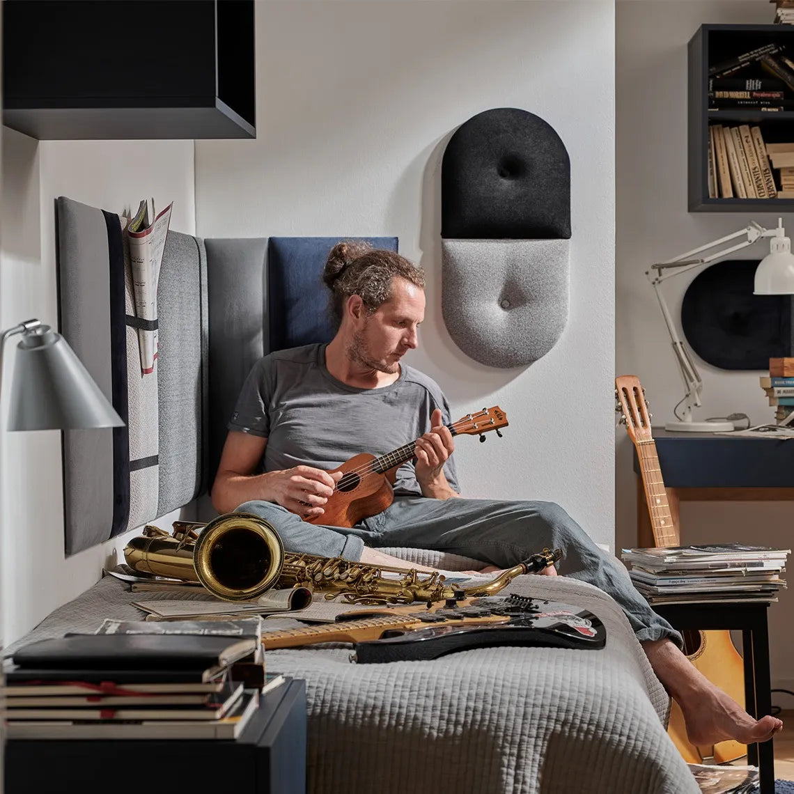 Padded Wall Panels Set 1 Grey in bedroom interior with a man playing instruments Decormania.eu