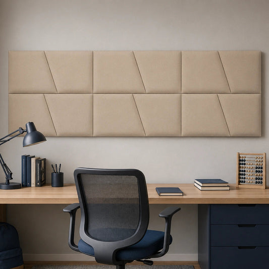 Front view of a large beige upholstered wall panel with geometric diagonal seams, displayed above a wooden desk in a modern study room