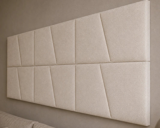 Close-up angled view of cream upholstered wall panels, highlighting their diagonal seams, padded relief, precise joints and textured fabric finish