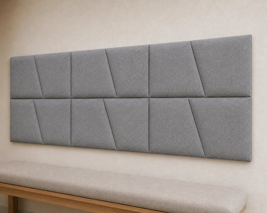 Close-up angled view of cream upholstered wall panels, highlighting their diagonal seams, padded relief, precise joints and textured fabric finish