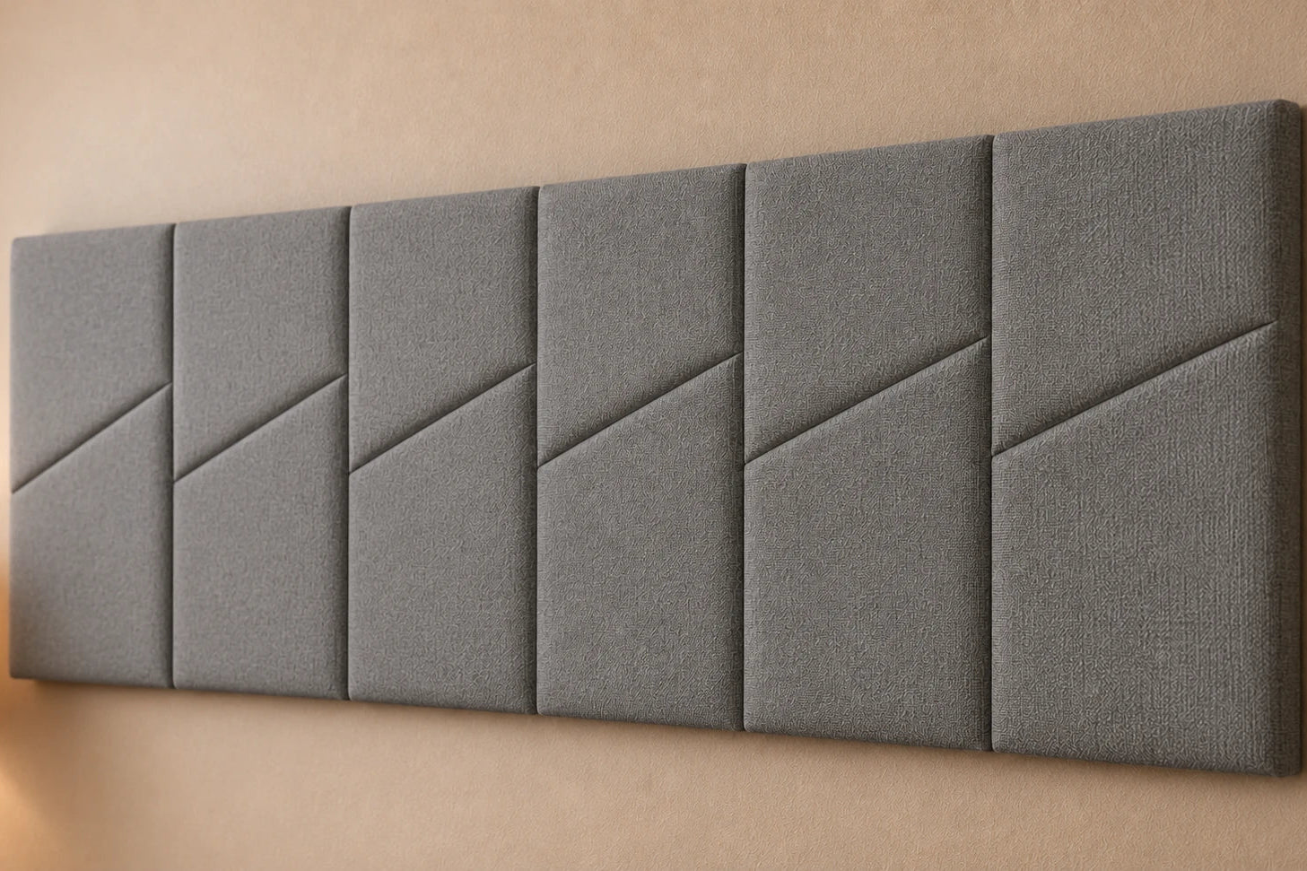 Close-up angled view of six grey padded wall panels, showing the woven fabric texture, diagonal seams and panel depth