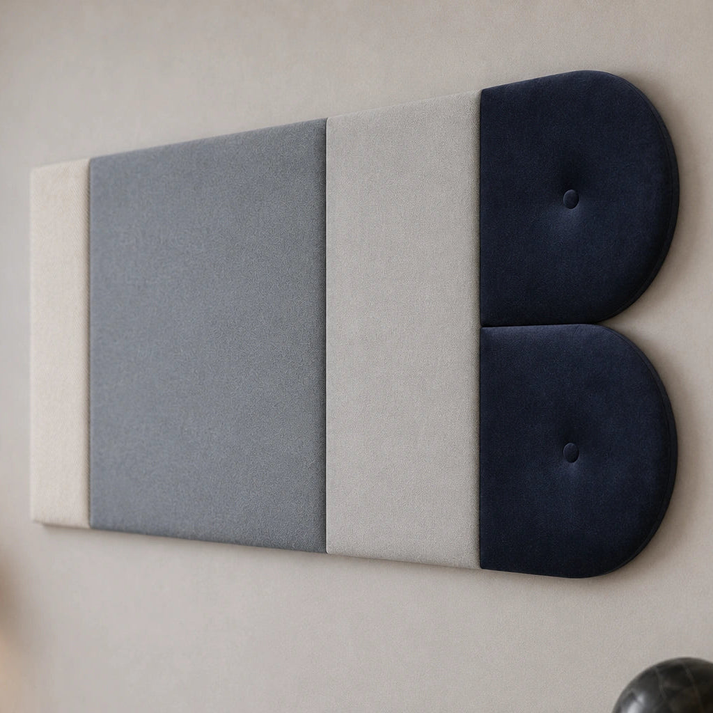 Close-up angled view of a grey and navy upholstered wall panel, highlighting its layered rectangular sections, twin rounded ends, fabric textures and matching button details