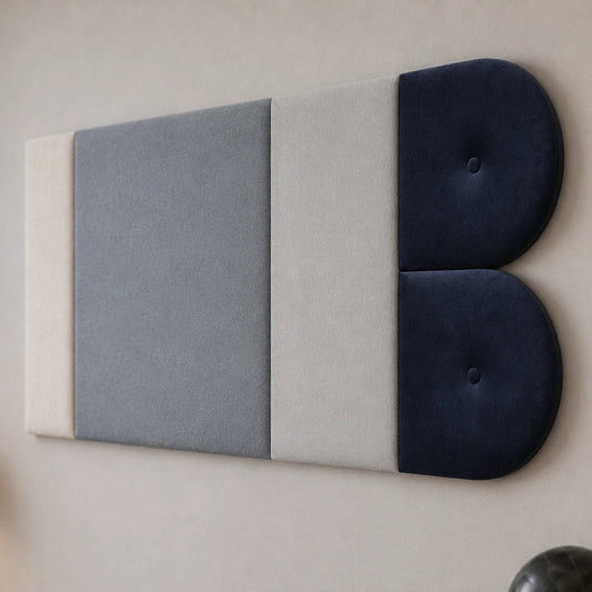 Close-up angled view of a grey and navy upholstered wall panel, highlighting its layered rectangular sections, twin rounded ends, fabric textures and matching button details