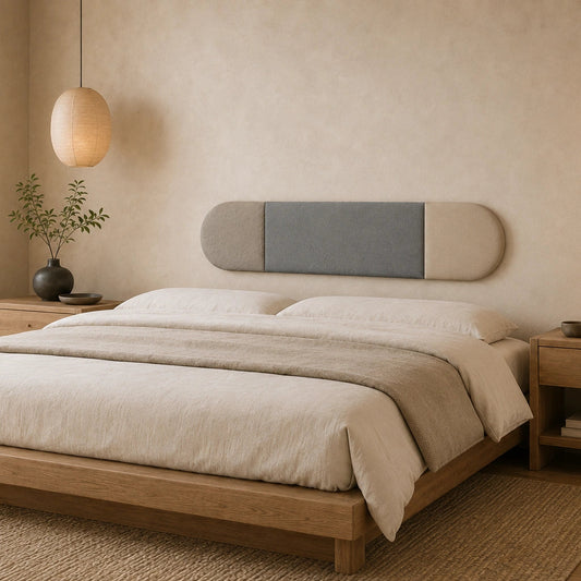 Angled view of a rounded grey and beige wall panel mounted above a bed in a calm, neutral bedroom with wooden furniture