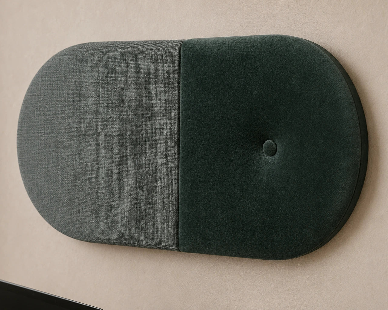 Close-up angled view of a two-tone green upholstered wall panel, highlighting its rounded shape, central seam, button detail and contrasting woven and velvety textures