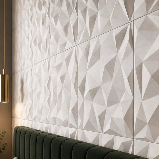 Close-up of white 3D gypsum wall panels showing their sharp, faceted rhinestone relief, fine surface texture, and precise square joints above a dark green upholstered headboard