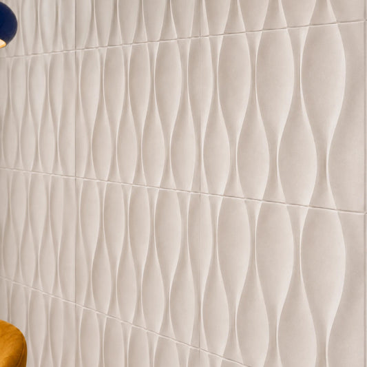 Close-up angled view of white 3D polystyrene wall panels, highlighting their smooth hourglass-shaped relief, subtle texture, and precise joints
