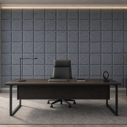 Front view of a modern executive office featuring grey 3D acoustic felt panels behind a dark wooden desk