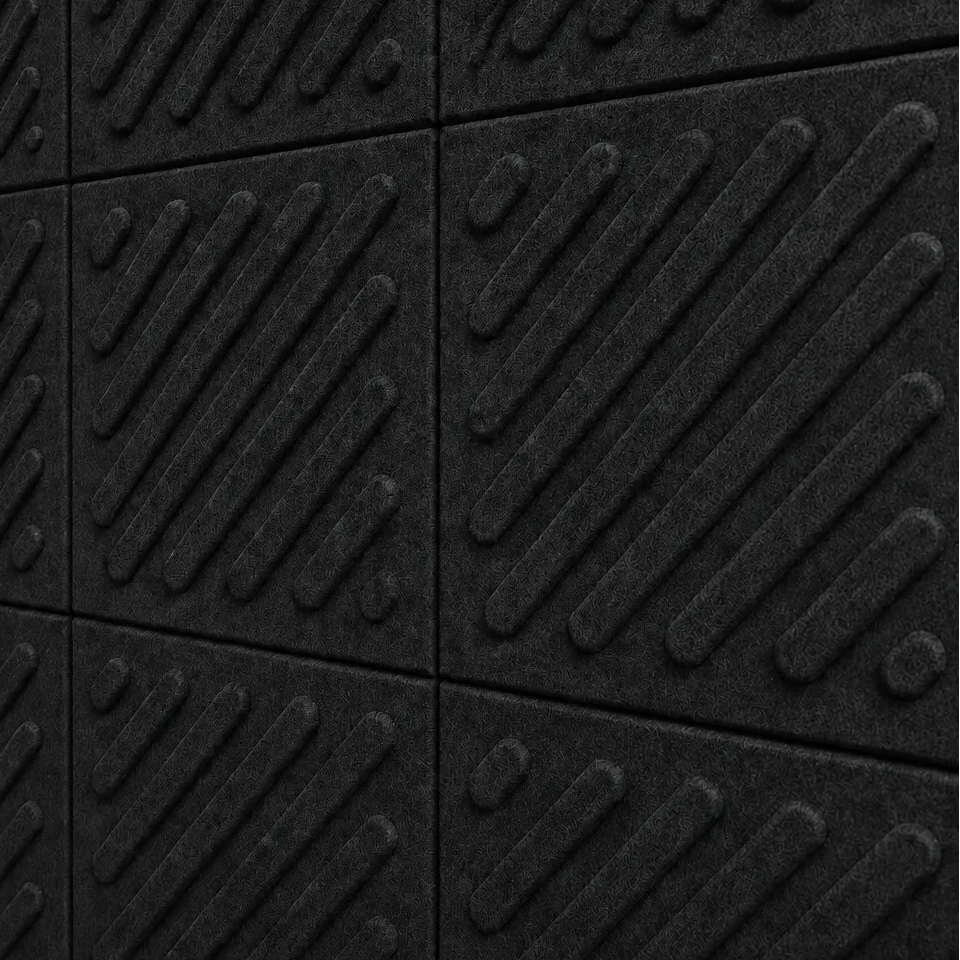 Close-up of black acoustic felt wall panels highlighting the fibrous texture, raised relief and module connections