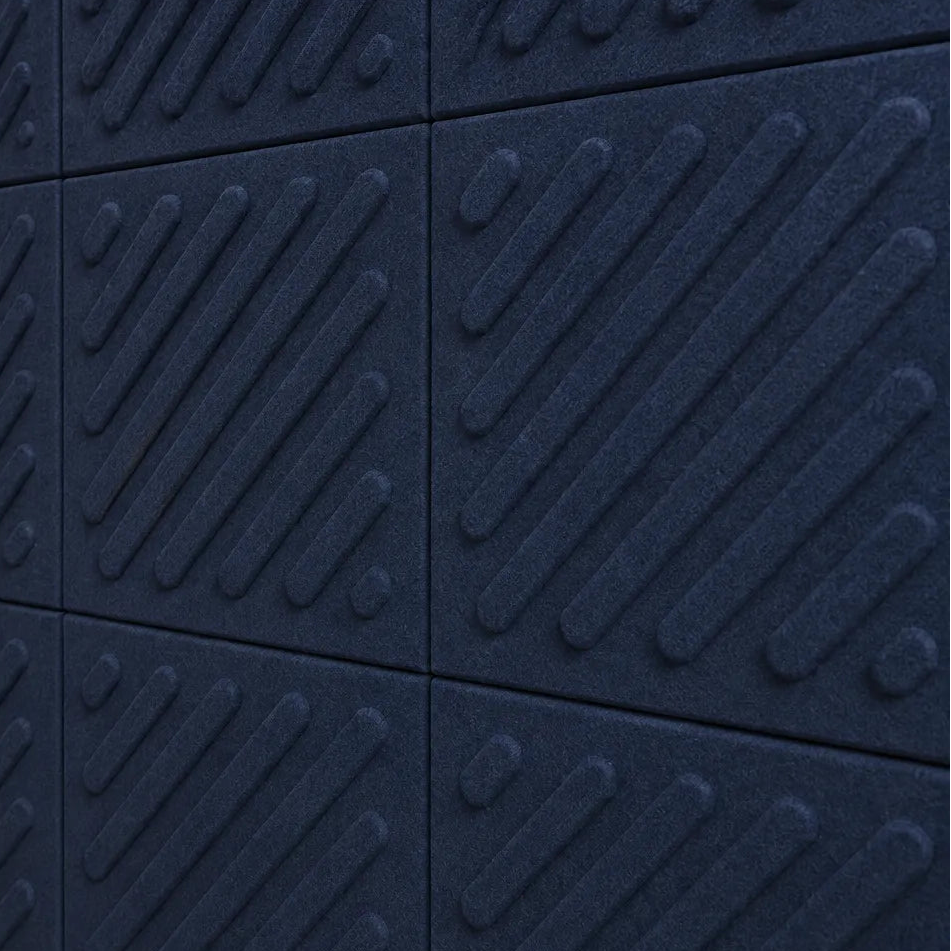 Close-up of navy acoustic felt wall panels highlighting the fibrous texture, raised relief and module connections