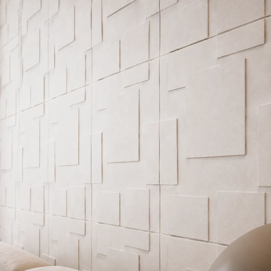 Close-up angled view of white gypsum 3D wall panels, showing the geometric relief, joints and textured surface