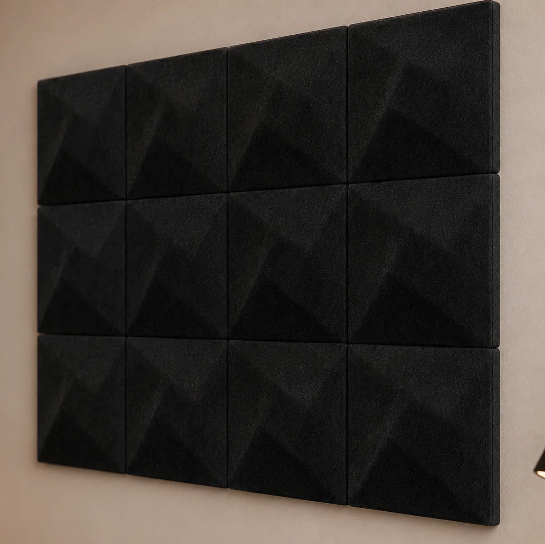 Close-up of black 3D felt acoustic panels showing the TWIST relief, panel joints and matte fibrous surface