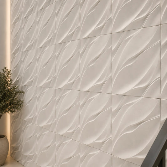 Close-up of white WAVES gypsum 3D wall panels showing their flowing relief, aligned joints and matte texture