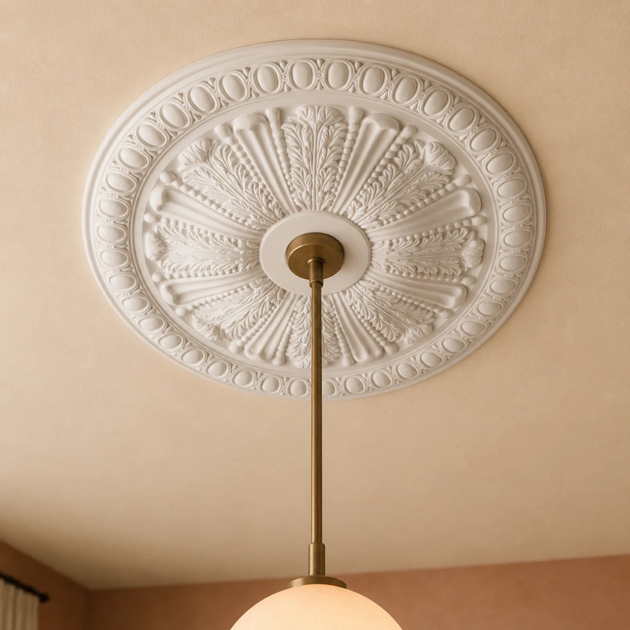 Close-up of the ornate white Francesca R75 ceiling rose with detailed leaves, fluting and oval border motifs around a brass pendant
